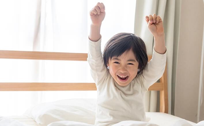 朝、目覚める子どものイメージ。